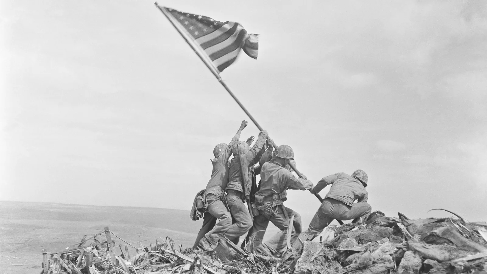 Cinco marines estadounidenses y un médico de la Armada levantan la bandera de Estados Unidos en el monte Suribachi durante la batalla de Iwo Jima de la Segunda Guerra Mundial.