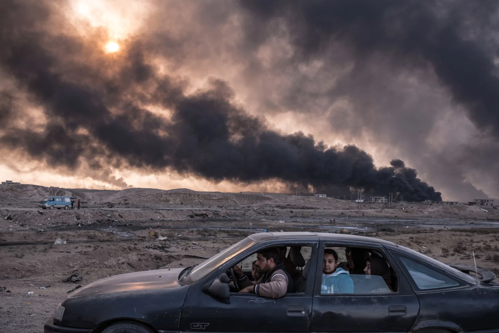 Una familia huye de Mosul, mientras se queman los campos petroleros en Qayyarah, 60 kilómetros al sur de la ciudad.
