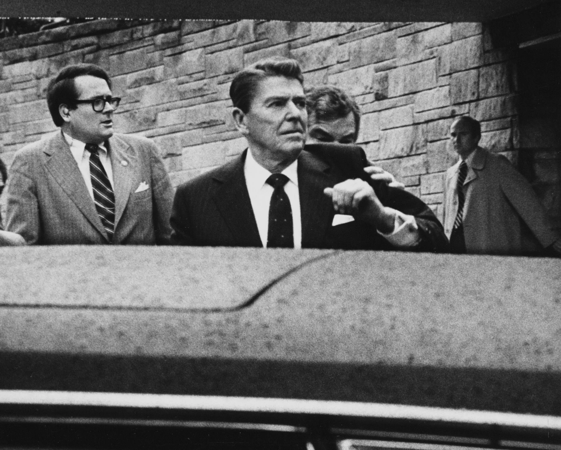 Un agente del servicio secreto empuja al presidente Ronald Reagan a su limusina después de que le dispararan al salir de un hotel. 
