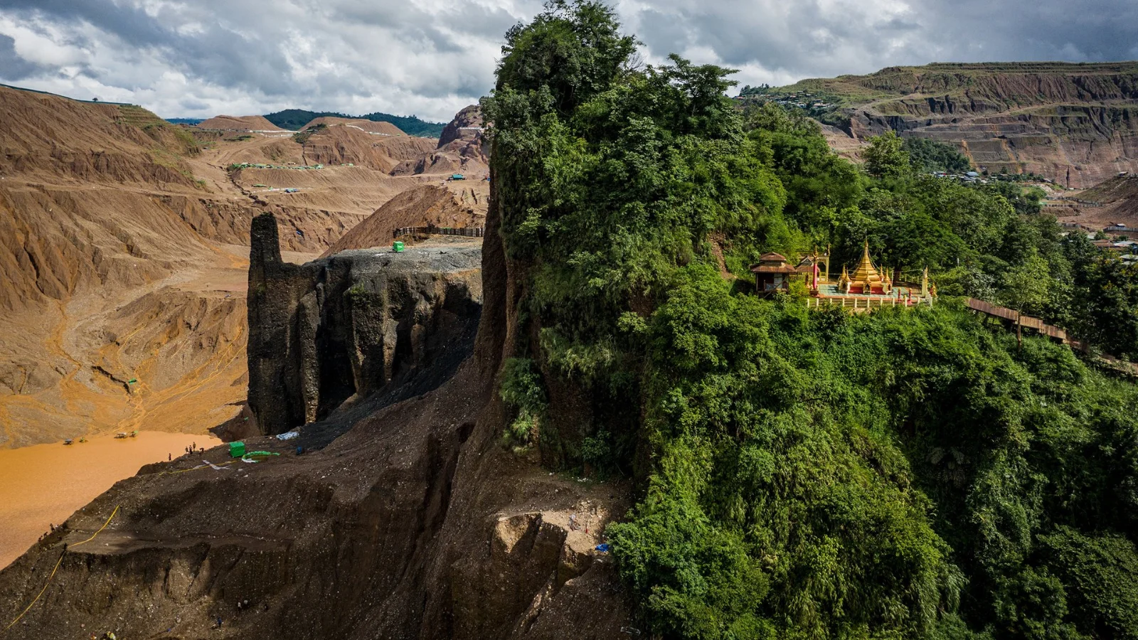 Um templo budista ocupa metade de uma montanha, enquanto a outra metade foi escavada por maquinaria pesada para extrair jade, em Hpakant.