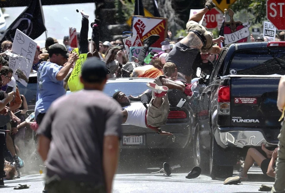 Las personas son lanzadas por los aires cuando un automóvil embiste a un grupo de manifestantes que protestan contra una manifestación de Unite the Right en Charlottesville.