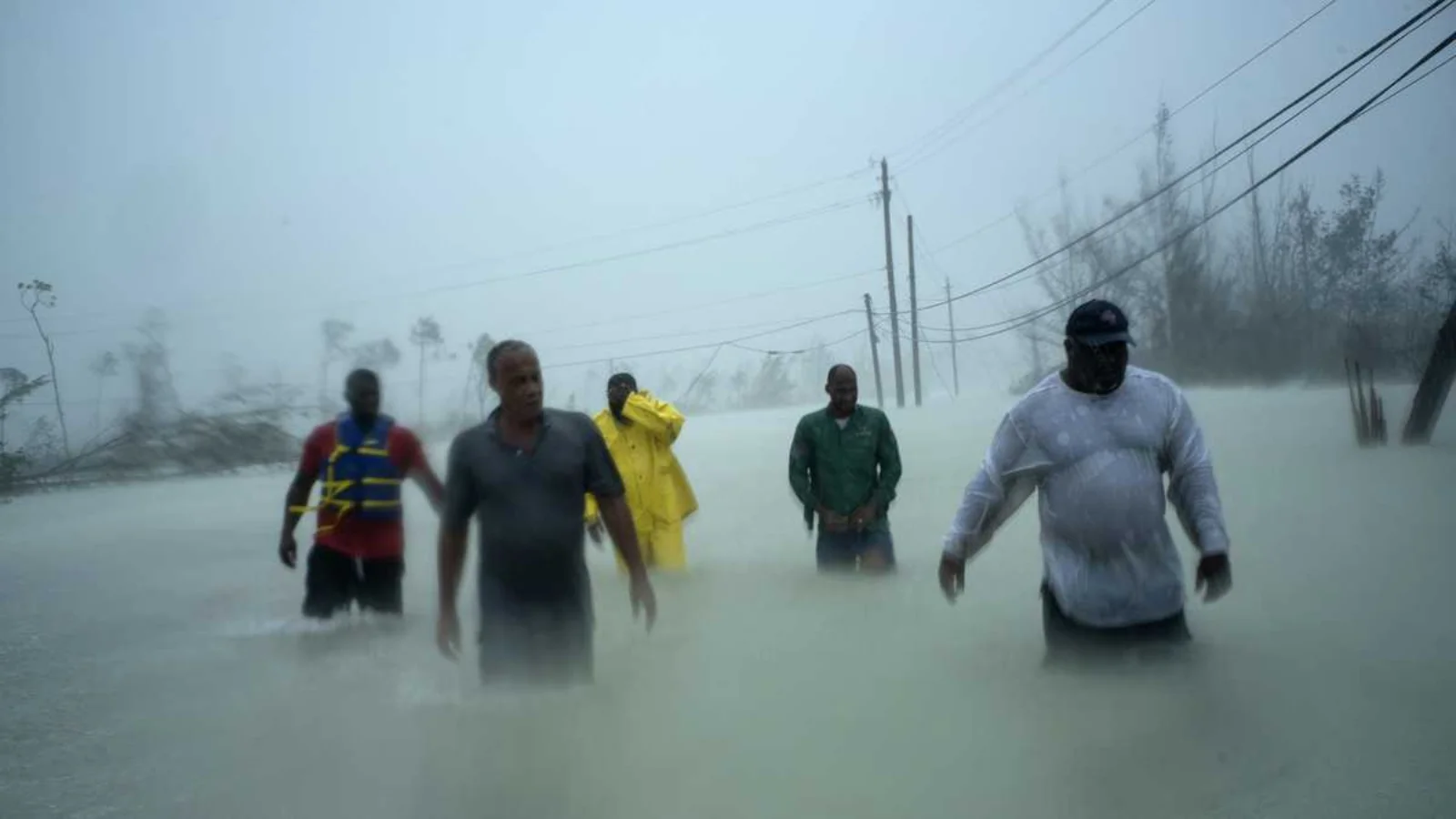 Voluntarios caminan por una carretera inundada en Freeport, Gran Bahama, después de que el huracán Dorian azotara la isla.