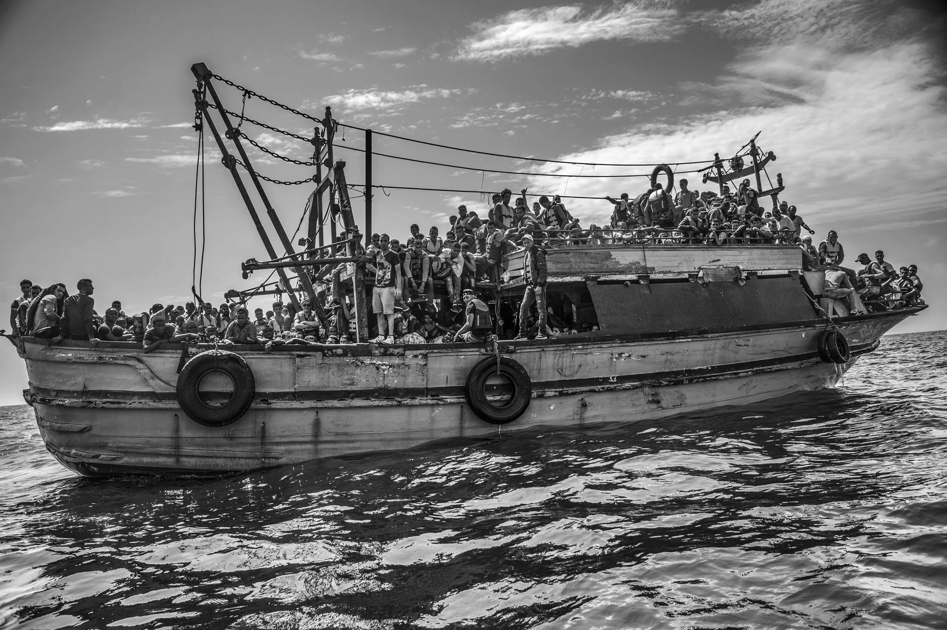 Un barco pesquero de madera, con más de 500 pasajeros, navega desde Libia en dirección a Italia.