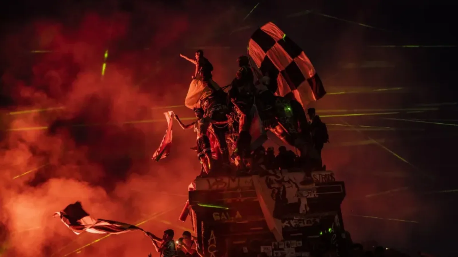 Protesters scale a statue in Plaza Baquedano.