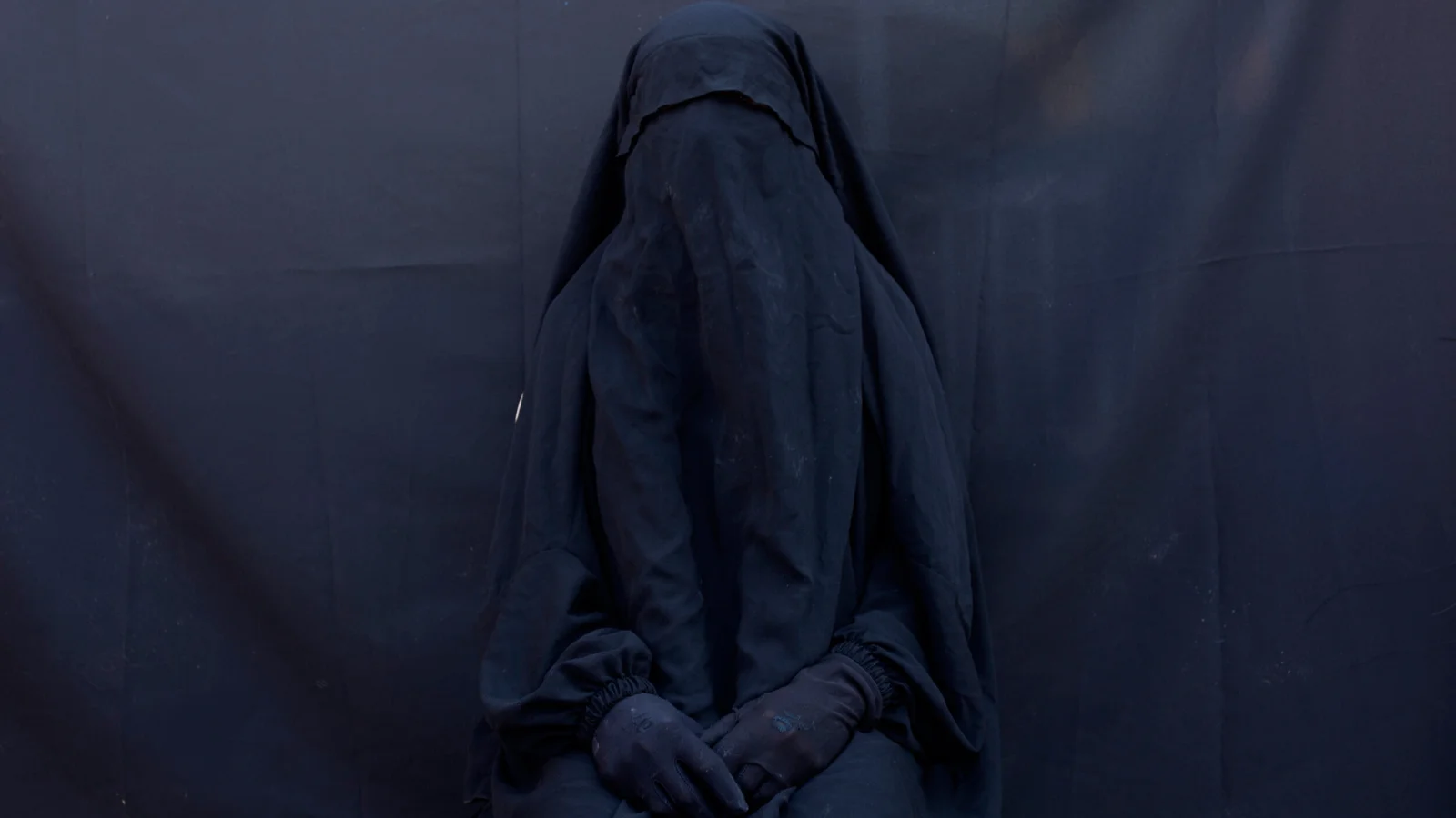 Layla Taloo posa para un retrato en su casa, con el velo integral y la abaya que usó mientras estuvo esclavizada durante dos años y medio por militantes del Estado Islámico.