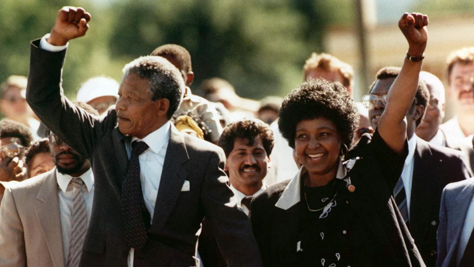 Nelson Mandela saliendo de la prisión de Victor Verster de la mano de Winnie, su esposa, ambos saludando triunfalmente con el puño cerrado.