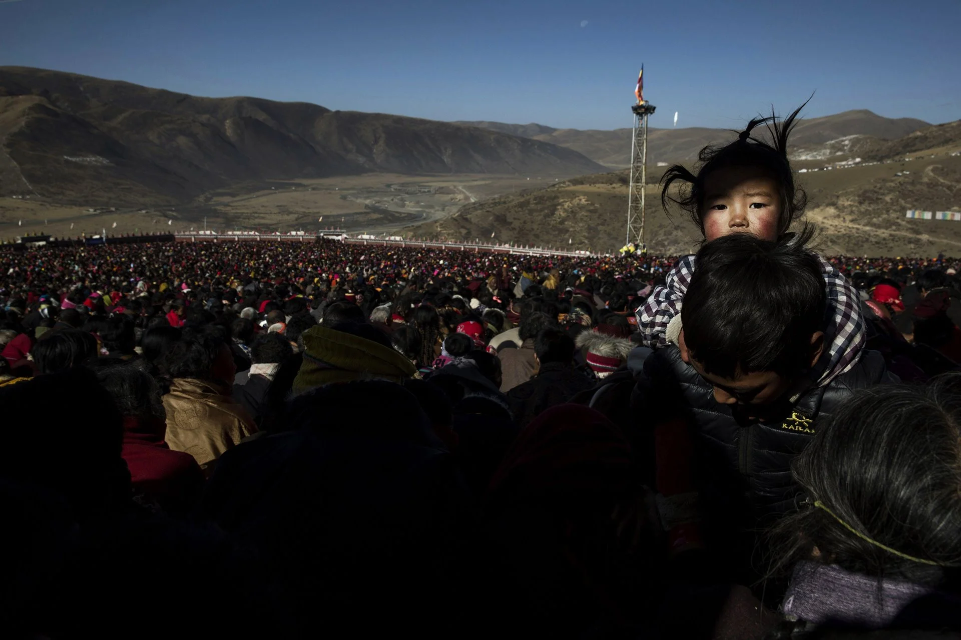 Un nómada lleva a su hija entre la multitud durante la asamblea.