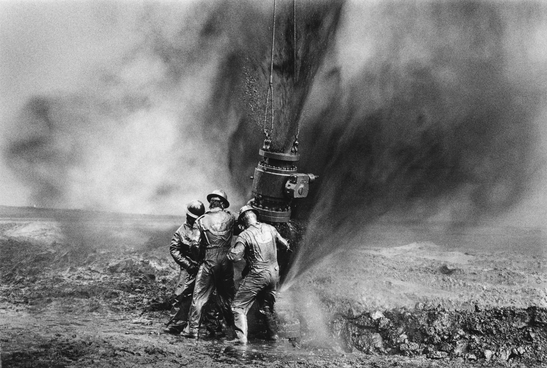 Trabajadores luchan por instalar un nuevo cabezal de pozo para detener las columnas de fuego. Cientos de pozos de petróleo kuwaitíes fueron saboteados por los iraquíes cuando partieron tras la guerra.