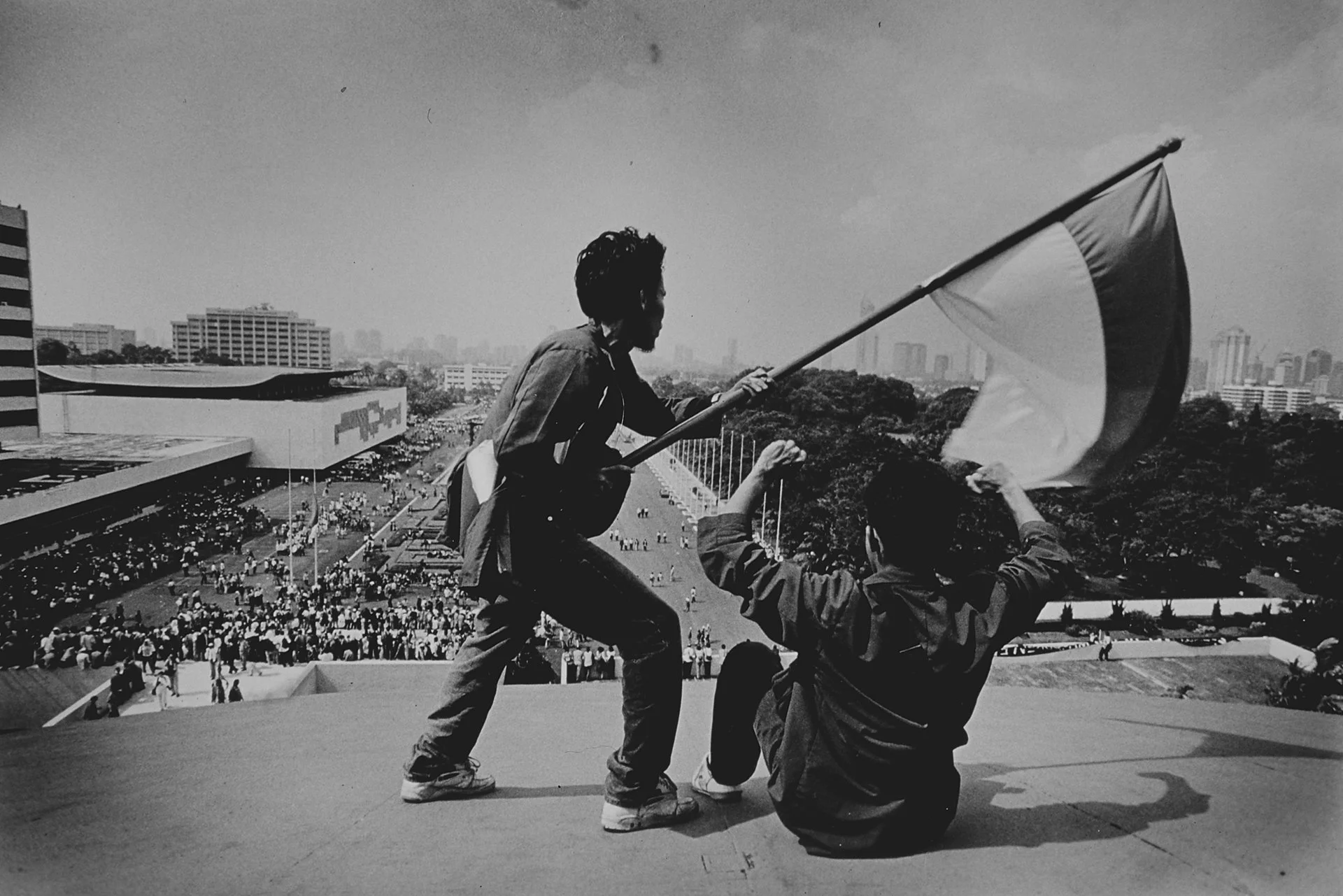 Students wave the national flag from the top of the parliament building ahead of President Suharto's resignation. Even after his resignation the riots continued.