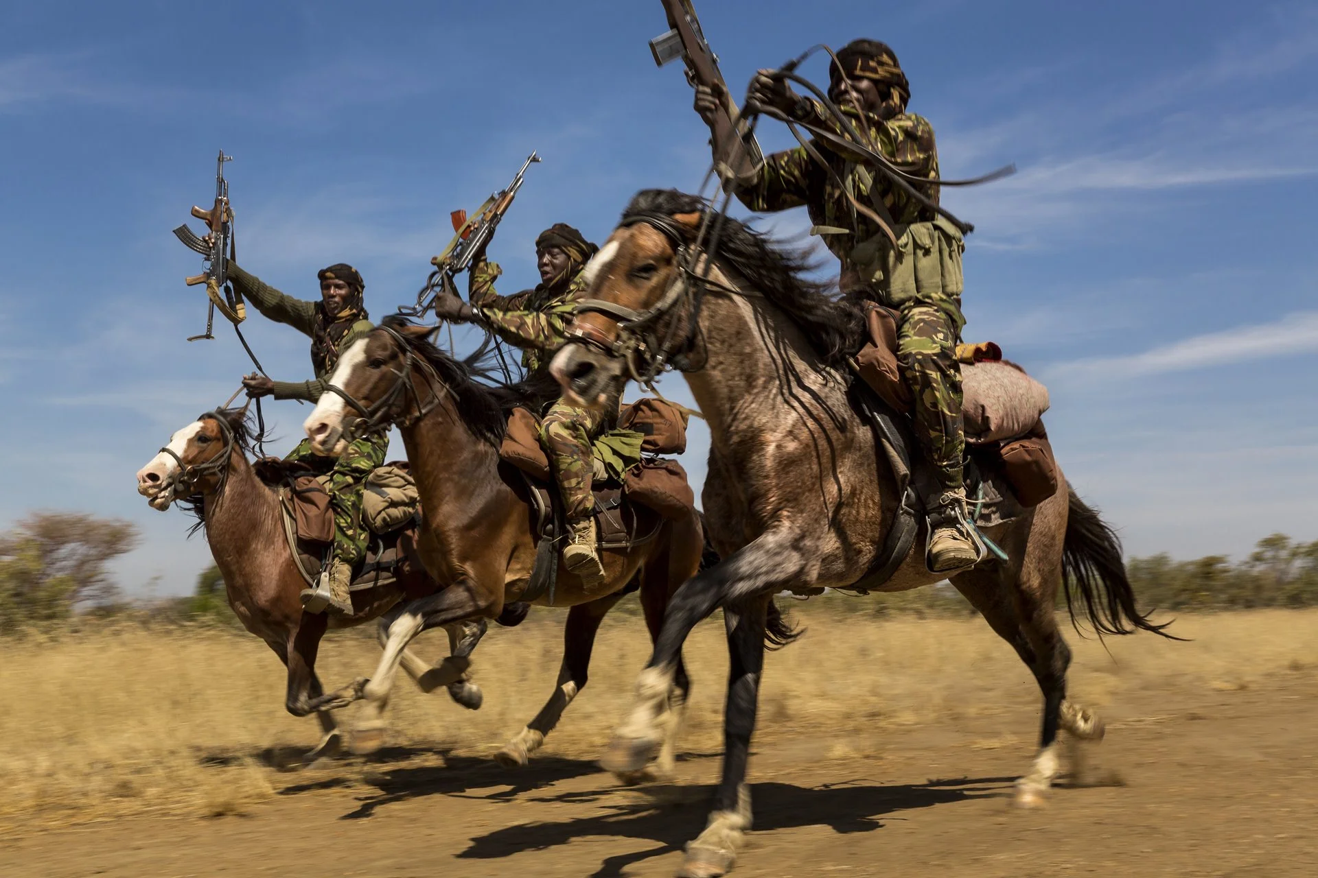 Los guardabosques exhiben sus habilidades de equitación cuando regresan a la base en el Parque Nacional Zakouma, Chad, después de semanas patrullando elefantes.