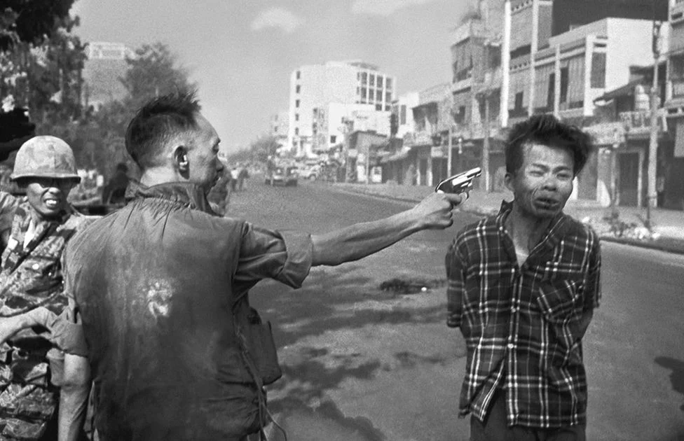 El general de Vietnam del Sur Nguyen Ngoc Loan, jefe de la policía nacional, dispara al oficial del Vietcong Nguyen Van Lem, también conocido como Bay Lop, en una calle de Saigón.