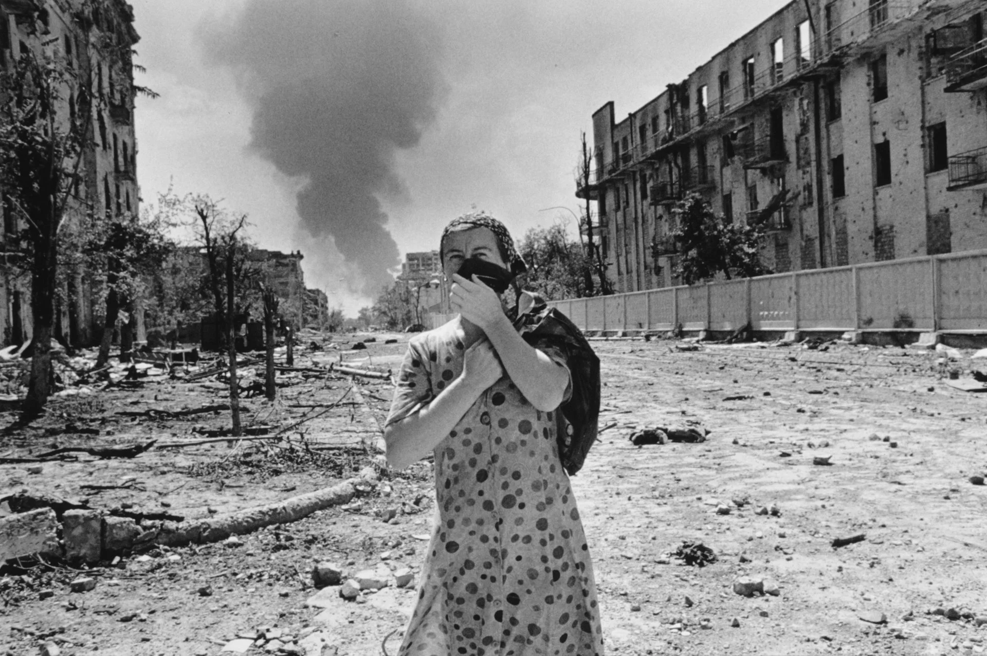 Una mujer permanece de pie aturdida en el campo de batalla urbano de Grozny, Chechenia.