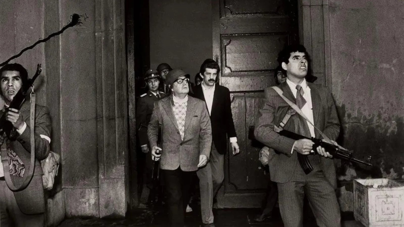 Chilean President Salvador Allende is flanked by bodyguards as he inspects the damage at the Moneda palace in Santiago on September 11.