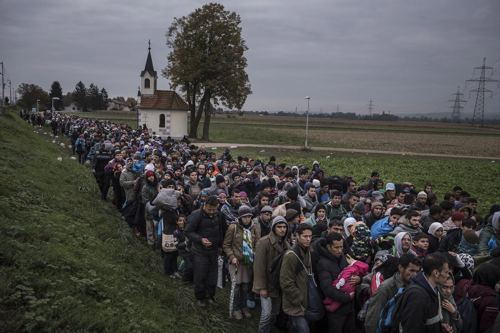 La gente camina hacia un campo de registro en las afueras de la ciudad eslovena de Dobova, cerca de la frontera con Croacia.