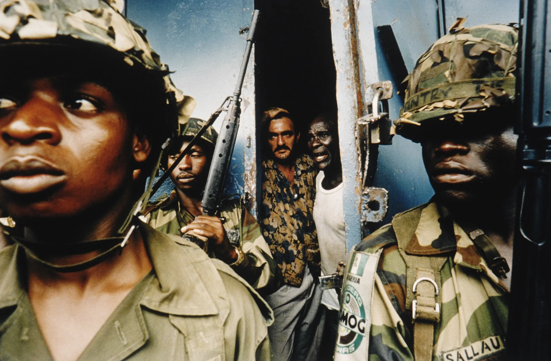 Los miembros nigerianos de la fuerza de mantenimiento de la paz de África occidental protegen a dos civiles asustados. En abril y mayo estalló la violencia desmedida en el país.