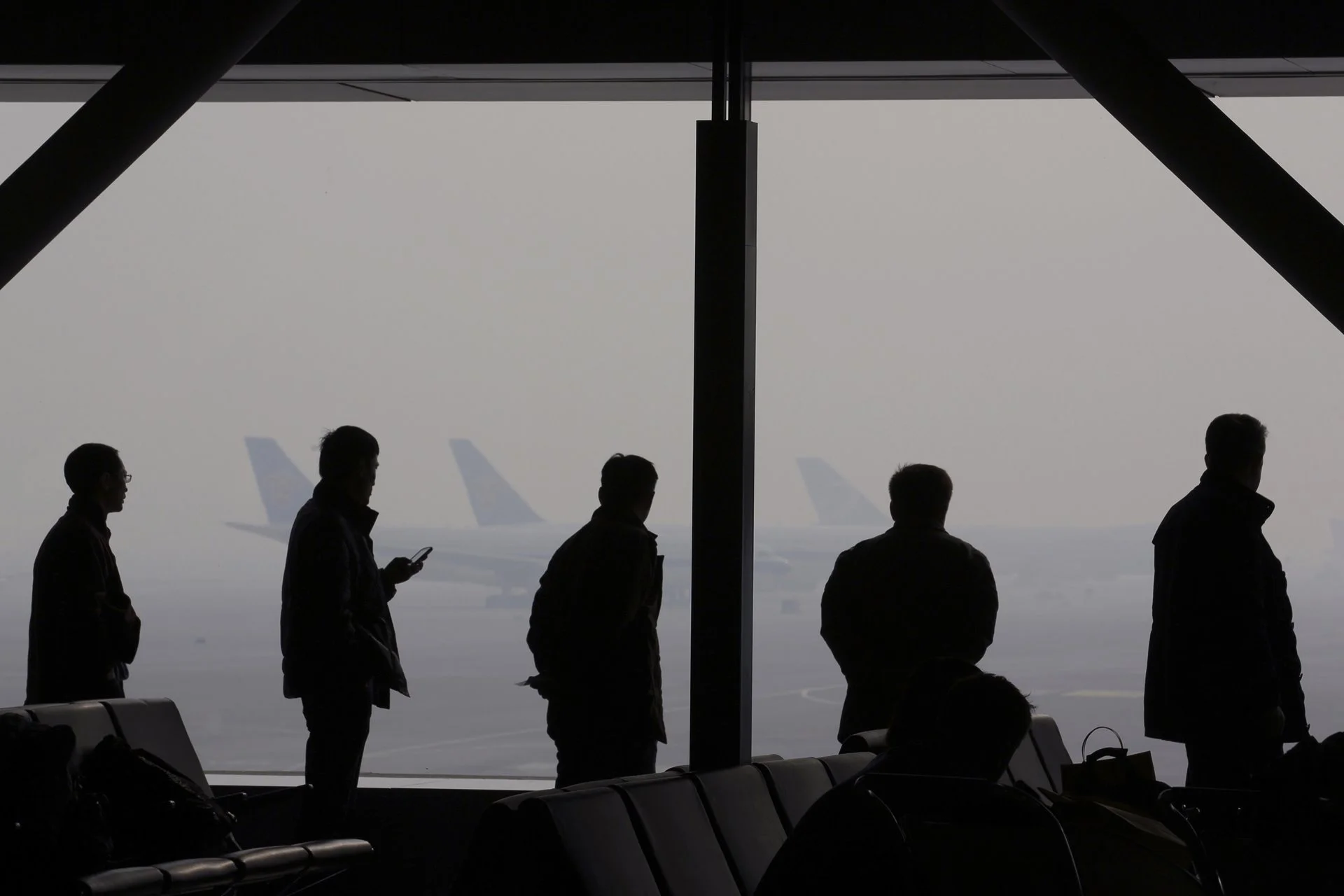 Severa neblina se produjo en el Aeropuerto Internacional de Beijing. Los pasajeros están esperando en el salón del aeropuerto.
